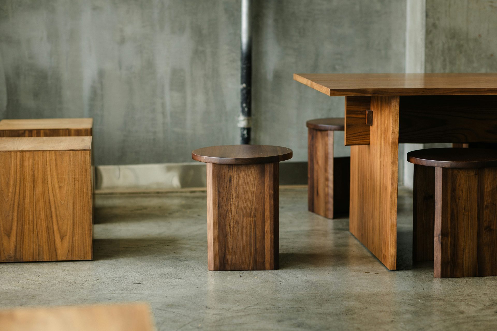 a group of wooden tables and stools in a room